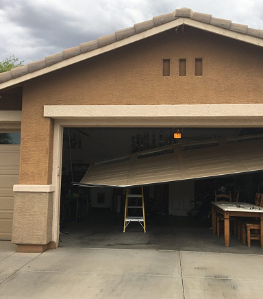 Broken garage door stuck halfway open due to opener malfunction.