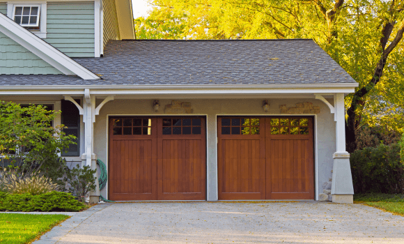 Wooden-style garage door installed on a home in Gilbert, AZ by Pride Garage Doors.